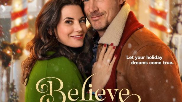 Ein Paar umarmt sich vor dem „The North Pole Inn“ für den Hallmark-Film „Believe in Christmas“.