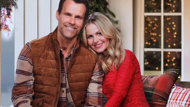 Ein Paar sitzt mit einem Beagle vor einem weihnachtlich geschmückten Haus, Titel „Home Sweet Christmas“.