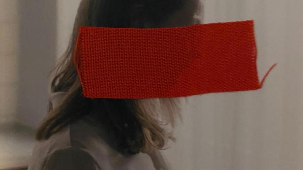 Das Filmplakat für „About a Hero“ zeigt eine Frau, deren Augen mit einem roten Balken bedeckt sind.