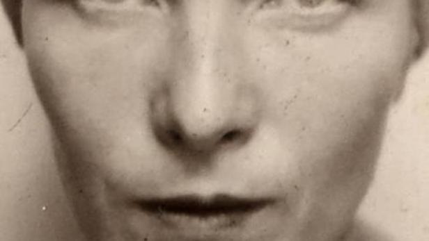 Schwarzweiß-Porträt einer Frau mit ernstem Blick und Turban.