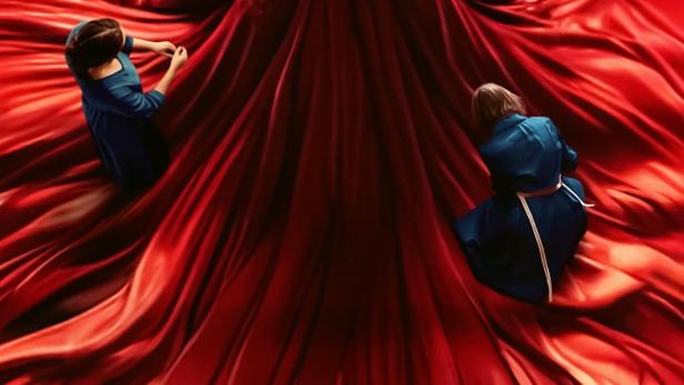 Das Filmplakat für „Diamanti“ zeigt eine Frau in einem roten Kleid, umgeben von rotem Stoff.