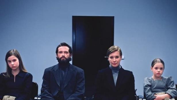 Eine Familie sitzt vor einer blauen Wand, darüber der Titel „quiet life“.