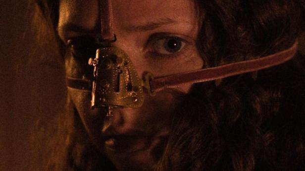 Eine Frau mit einer mittelalterlichen Gesichtsmaske, möglicherweise aus dem Film „The Ugly Stepsister“.