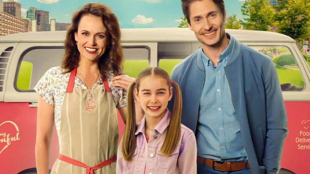 Das Filmplakat für „Food for the Heart“ zeigt eine Frau, ein Mädchen und einen Mann vor einem Lieferwagen.