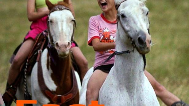 Zwei junge Frauen reiten auf Pferden durch eine grüne Landschaft.