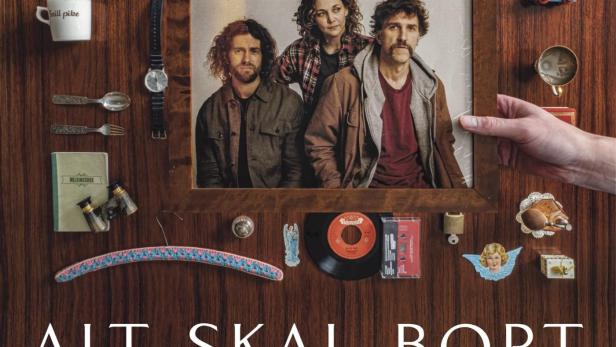 Das Filmplakat für „Alt Skal Bort“ zeigt drei Personen in einem gerahmten Foto, umgeben von verschiedenen Objekten.