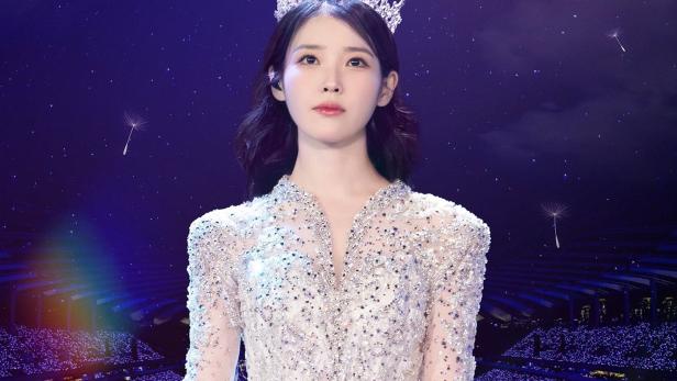 IU, gekleidet in einem glitzernden Kleid und einer Krone, auf der Bühne für ihr Konzert „The Winning“.