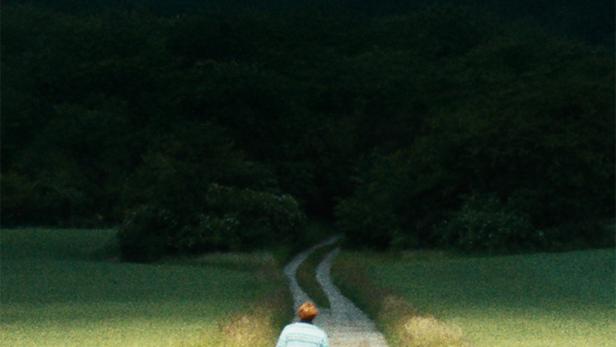 Das Filmplakat für „Kära Mor“ zeigt einen Mann, der einen Feldweg entlanggeht.