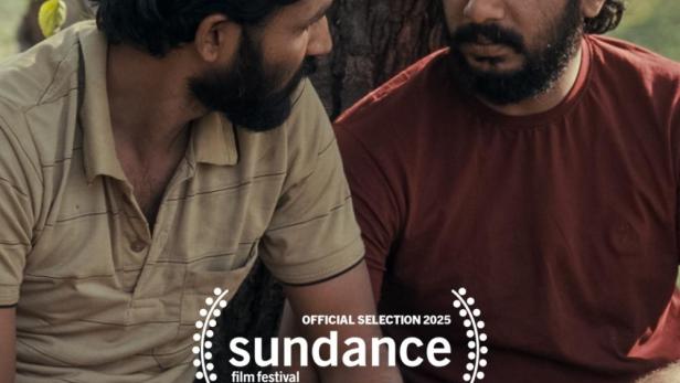 Zwei Männer sitzen an einem Baum und halten Hände.