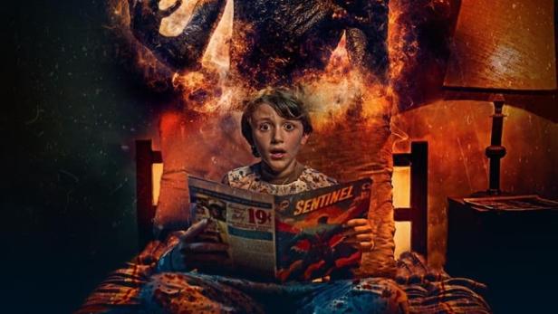 Ein Junge liest im Bett eine „Sentinel“-Comic, während eine brennende Gestalt über ihm steht.