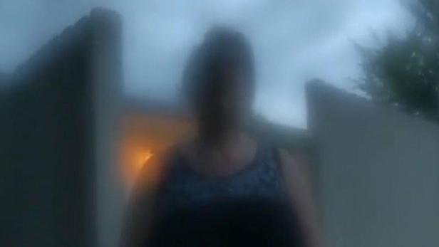 Eine verschwommene Person steht vor einem Haus, überlagert vom Titel „The Perfect Neighbor“.