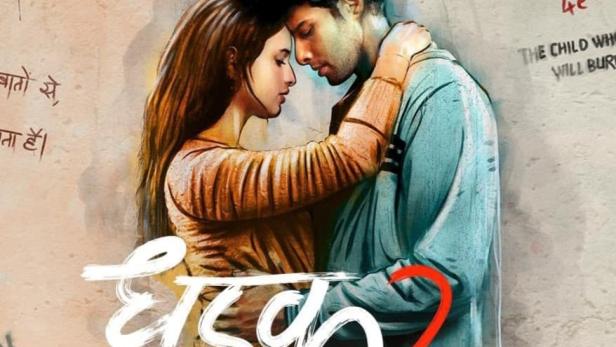 Ein Paar umarmt sich vor dem Hintergrund des Filmplakats „Dhadak 2“.