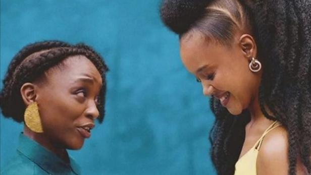 Das Filmplakat für „Umjolo: There Is No Cure“ zeigt zwei Frauen vor einem blauen Hintergrund.