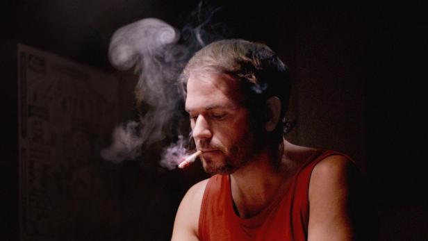 Ein Mann mit Zigarette sitzt an einem Zeichentisch; Filmposter „Serie Tecknaren“.