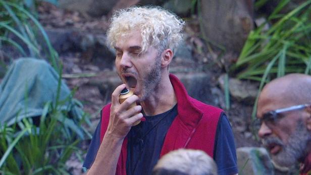 Sam Dylan sprüht sich im Dschungelcamp etwas in den Mund.
