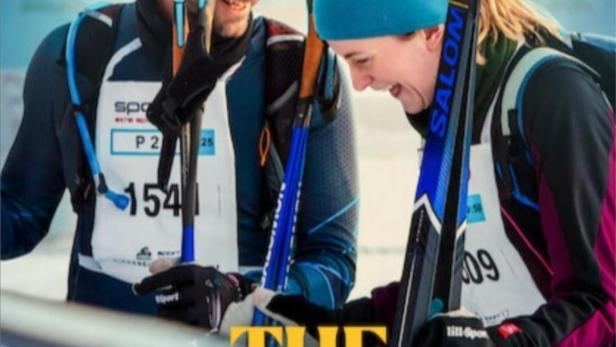 Ein Mann und eine Frau mit Skiern vor dem Poster für den Film „The Wrong Track“.