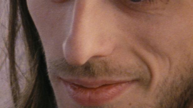 Nahaufnahme eines Mannes mit Bart und langen Haaren.