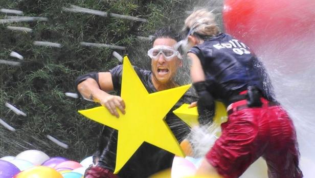 Timur Ülker und Edith Stehfest während einer Challenge mit Wasser und gelben Sternen.