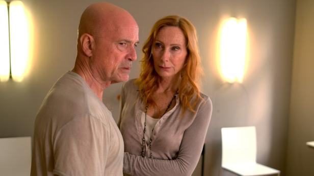 Ein Mann und eine Frau stehen in einem Raum und schauen einander an.