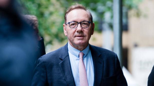 Kevin Spacey trägt einen Anzug und eine Brille.