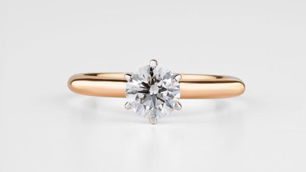 Ein goldener Verlobungsring mit einem kleinen Diamanten in der Mitte.
