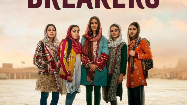 Fünf junge Frauen stehen vor dem Schriftzug „Rule Breakers“.