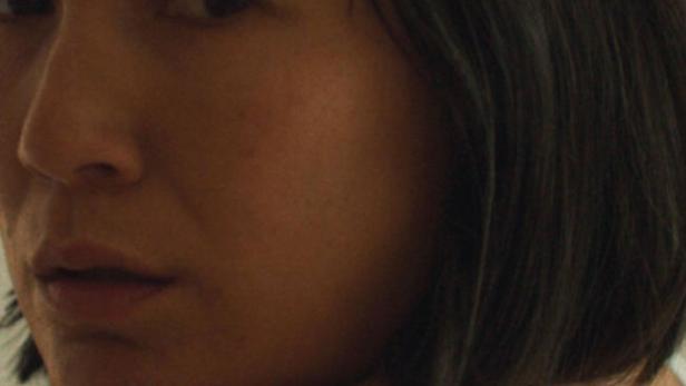 Porträt einer Frau mit dunklen, kinnlangen Haaren.