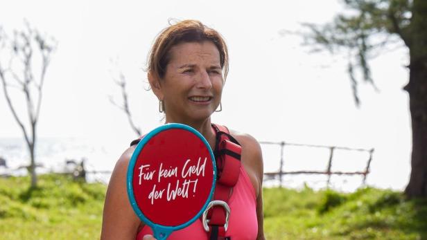 Claudia Obert posiert mit einem roten Schild, auf dem „Für kein Geld der Welt!“ steht.