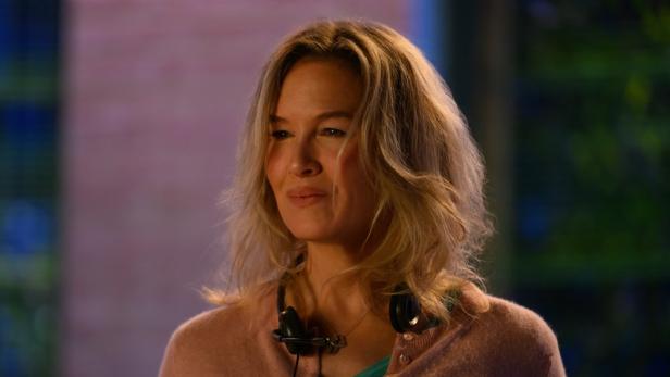 Renée Zellweger als Bridget Jones mit einem Headset um den Hals.