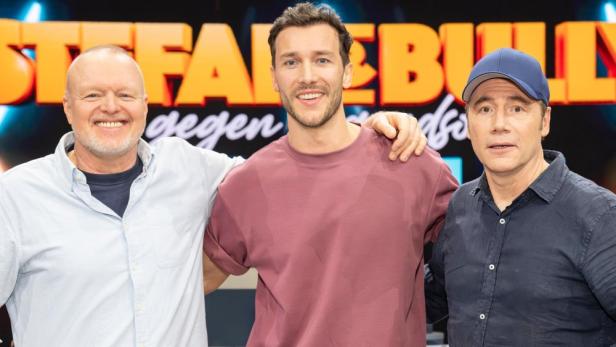Stefan Raab, Michael „Bully“ Herbig und ein weiterer Mann posieren vor dem „TV total“-Logo.