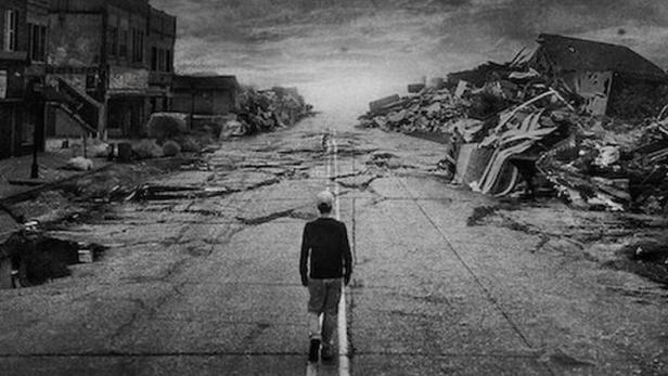 Ein Mann geht eine zerstörte Straße entlang, im Hintergrund Trümmer und der Schriftzug „The Twister“.