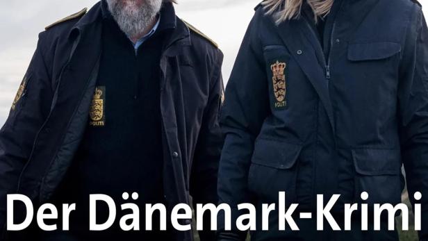 Zwei dänische Polizisten in Uniform stehen vor einer trüben Landschaft.