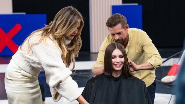 Heidi Klum und ein Friseur schneiden einer jungen Frau die Haare.