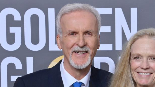 James Cameron posiert mit einer Frau vor dem Hintergrund der Golden Globes.
