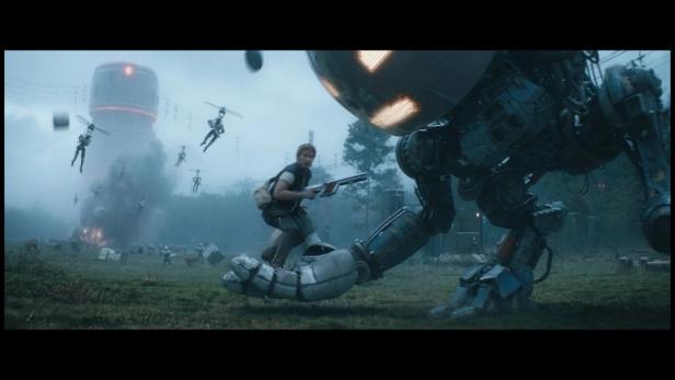 Ein Mann reitet auf der Hand eines Roboters, während im Hintergrund Drohnen fliegen.