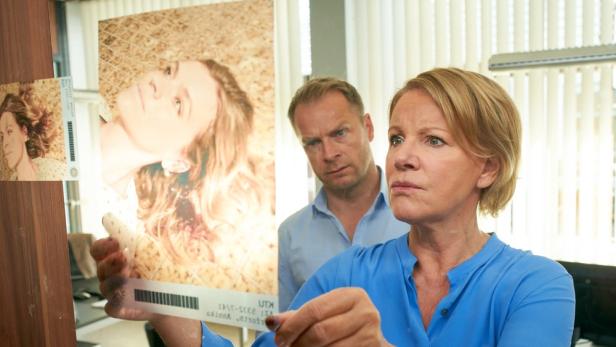 Marie Brand und ein Kollege betrachten Fotos eines Leichnams.