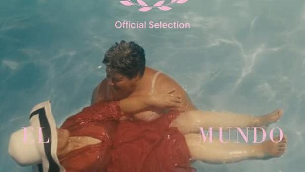 Zwei Frauen schwimmen im Wasser, Filmtitel „El Viaje al Mundo Real“ sichtbar.