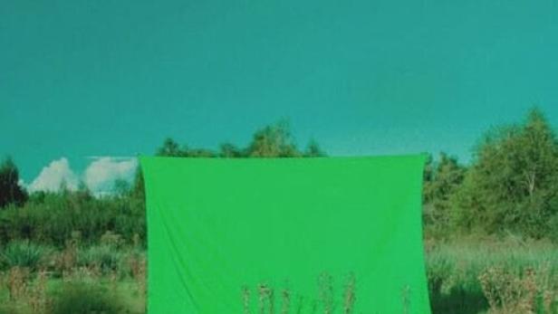 Das Filmplakat für „Croma“ zeigt eine Gruppe grün gekleideter Personen vor einer grünen Leinwand.