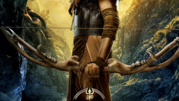 Ein Mann mit Bart und Fellkragen hält einen Knochenbogen in einer Fantasielandschaft.