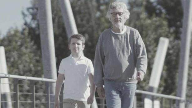 Das Filmplakat für „Carl.“ zeigt einen Jungen und einen älteren Mann, die auf einer Brücke laufen.