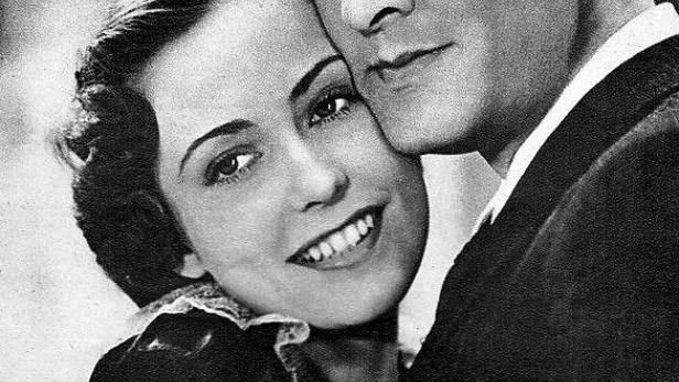 Ein Schwarzweißfoto von einem Paar, das sich umarmt, mit dem Titel „Schloß Vogeloed“ im Vordergrund.