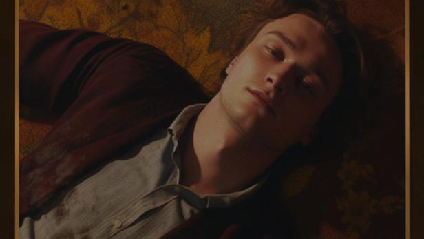 Ein Mann liegt auf einem gemusterten Untergrund, Filmtitel „Le Paillasson“.