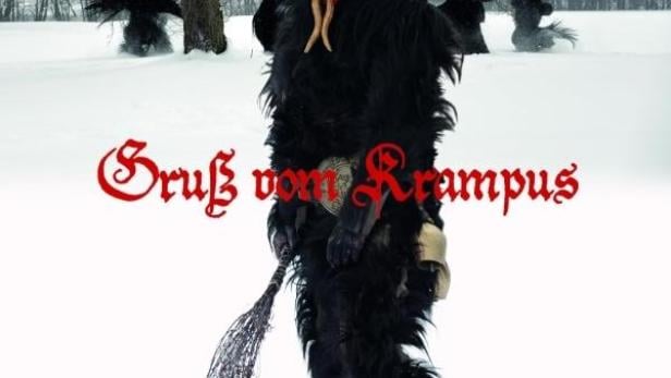 Ein Krampus mit roter Maske und Hörnern steht im Schnee.