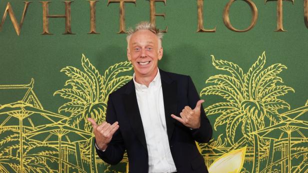 Mike White posiert vor einem Hintergrund für die Fernsehserie „The White Lotus“.