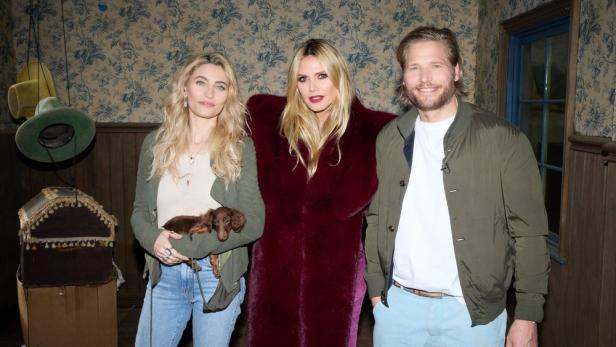 Heidi Klum, Paris Jackson und Sebastian Ströbel posieren zusammen; Jackson hält einen Dackel im Arm.