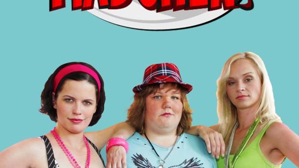 Drei Frauen posieren vor dem Schriftzug „Böse Mädchen“.