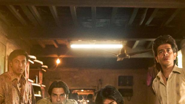 Das Filmplakat für „Die Superboys von Malegaon“ zeigt vier Männer und eine Kamera auf einem Fahrrad.