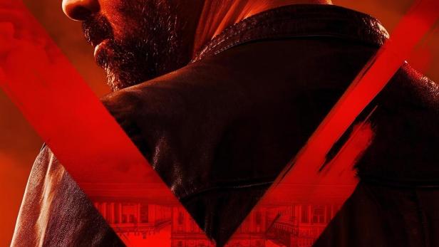 Ein Mann in Lederjacke, im Hintergrund ein rotes X und arabische Schriftzeichen.