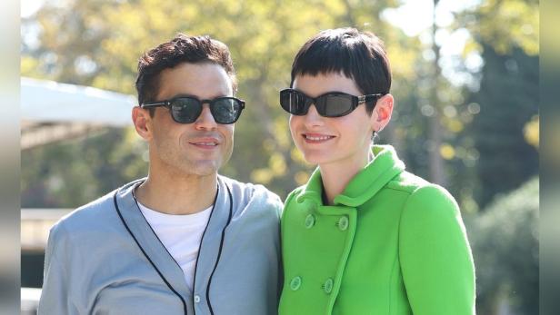 Rami Malek und Emma Corrin posieren zusammen im Freien.