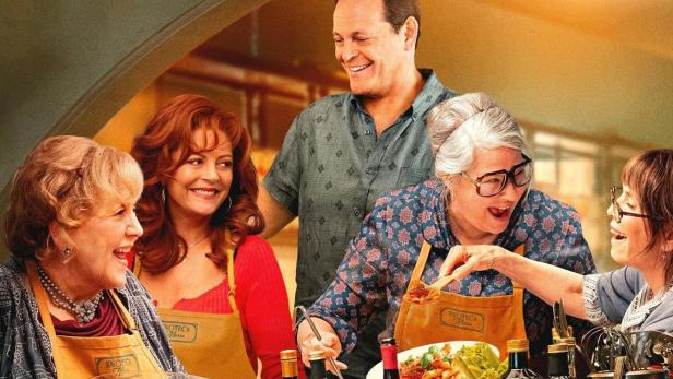 Das Filmplakat zu „Nonnas“ zeigt eine Gruppe von Frauen und einen Mann beim gemeinsamen Kochen.